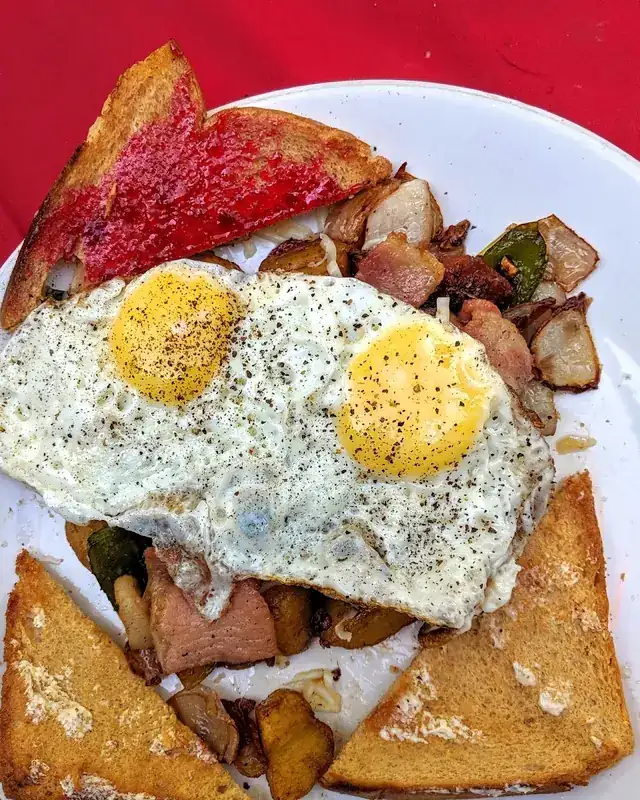 Two fried eggs over hash with chilli toast