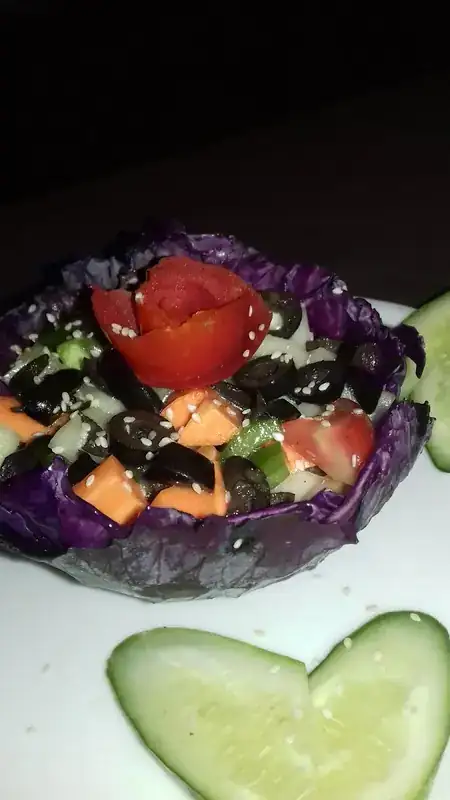 Salad served in a purple cabbage bowl
