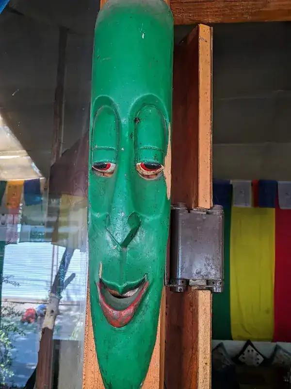 Painted Himalayan mask hanging by the door